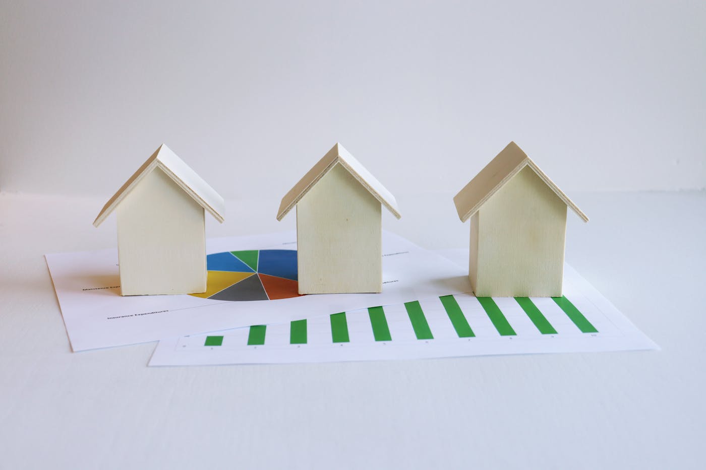 Wooden house models on investment growth charts